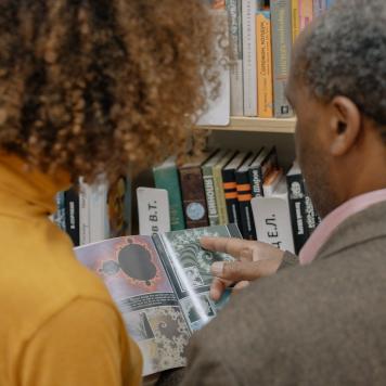 Zwei Schwarze UniversitÃÂ¤tsmitglieder schauen in ein Buch